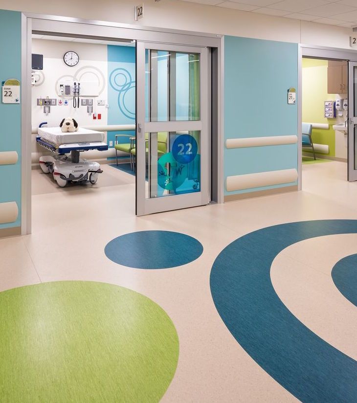 In A Medical Clinic - Bright Colored Corridor With Rooms Having Bed & Medical Equipment.